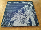 Album cover for 'Spiritual Healing' with black and white illustrations on a wooden surface